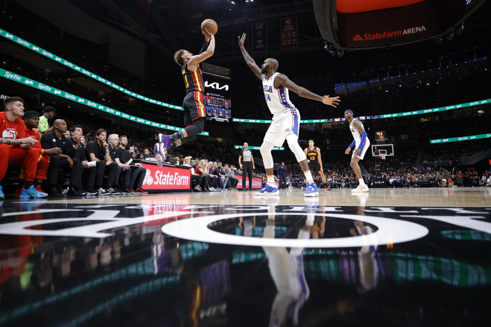 Atlanta Hawks guard Trae Young, left, shoots against Philadelphia 76ers center Dewayne Dedmon during the first half of an NBA basketball game Friday, April 7, 2023, in Atlanta. (AP Photo/Alex Slitz)