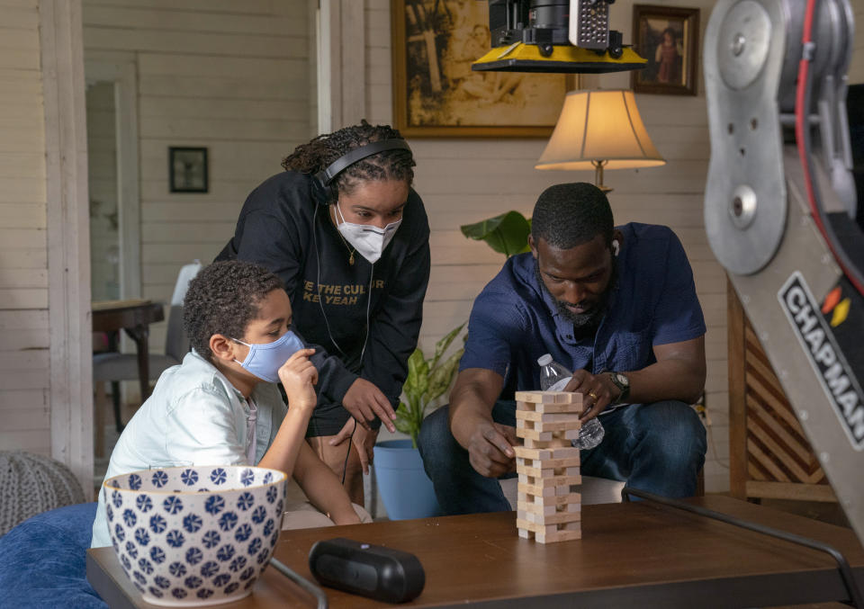 This image released by Warner Bros. Entertainment shows director Cierra Glaude, center, with Kofi Siriboe, right, and Ethan Hutchison as they set up a scene for “Queen Sugar." When the series debuted in 2016, Glaude worked as a production assistant on the show. Five years later, she’s been promoted to director for season five on the Oprah Winfrey Network series. (Skip Bolen/2020 Warner Bros. Entertainment via AP)