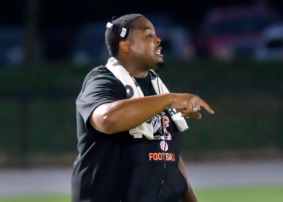 Manual head coach Dennis Bailey gives directions to his team as they battle Peoria High in the first half of their varsity football game Friday, Sept. 22, 2023 at Peoria Stadium. The Lions defeated their rival Rams 58-0.