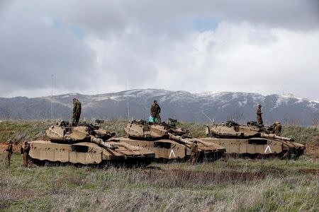 Israeli soldiers stand atop tanks in the Golan Heights near Israel's border with Syria March 19, 2014. REUTERS/Ronen Zvulun/Files