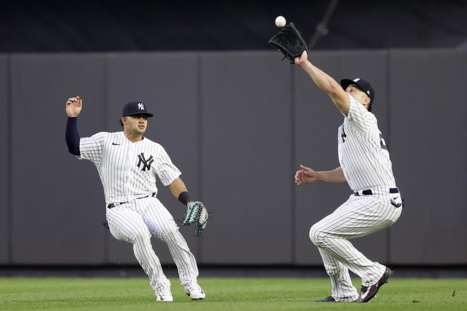 New York Yankees center fielder Jasson Dominguez, left, watches Giancarlo Stanton make a catch on a sacrifice fly hit by Milwaukee Brewers' Victor Caratini during the eighth inning of a baseball game Saturday, Sept. 9, 2023, in New York. (AP Photo/Adam Hunger)