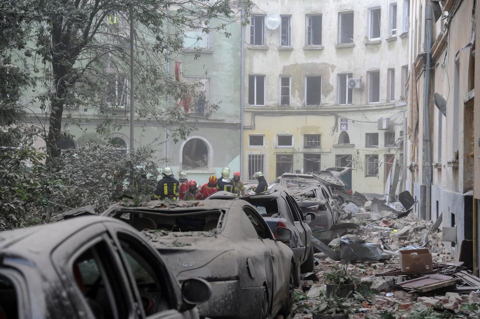 Emergency service workers gather outside damaged buildings after a Russian missile attack in Lviv, Ukraine, on July 6, 2023.