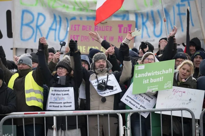 Several farmers hold hands during a rally in front of the Brandenburg Gate. The protests are directed against planned subsidy cuts by the federal government, including for agricultural diesel. Sebastian Christoph Gollnow/dpa