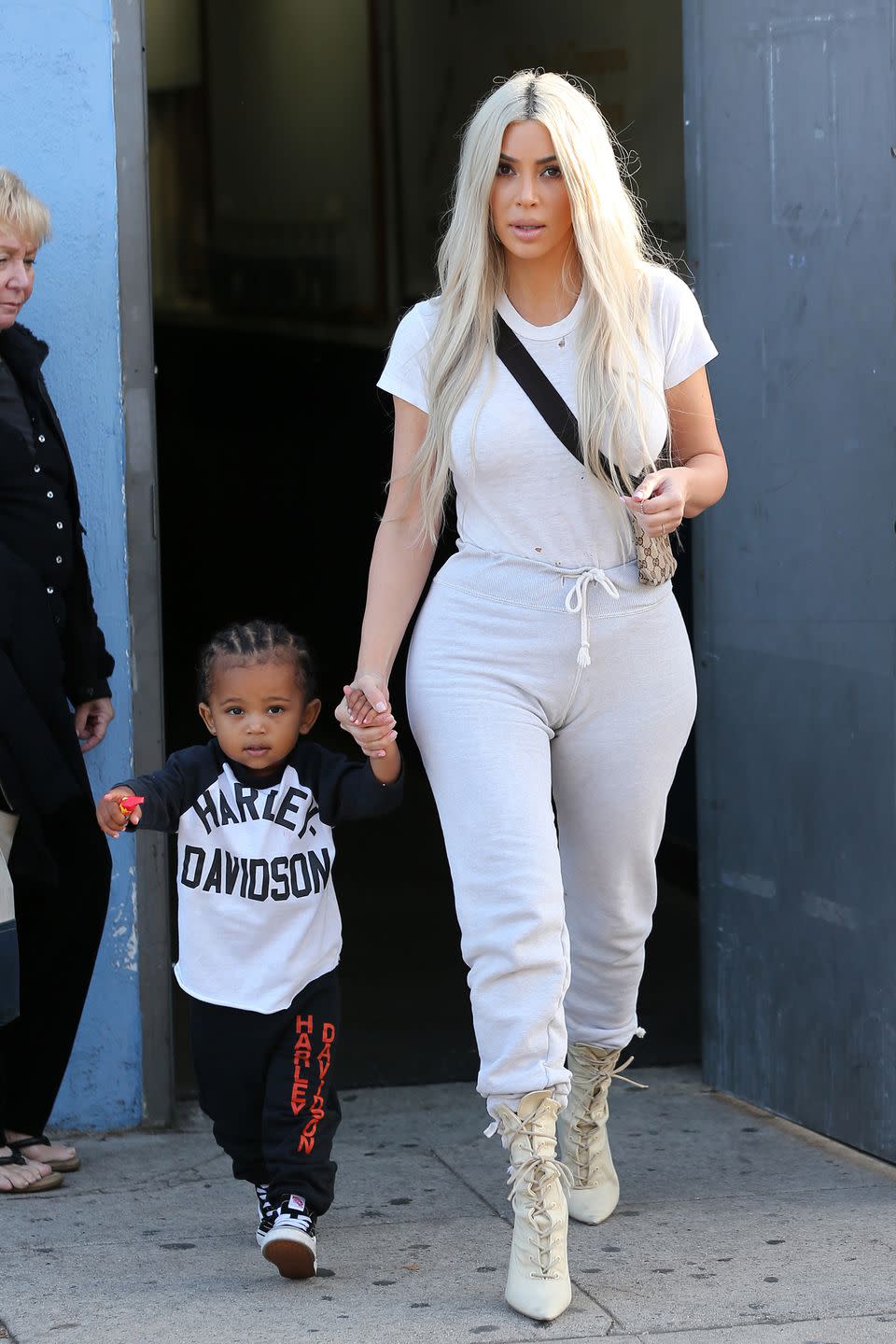 <p>In a white tee, grey drawstring sweatpants, Gucci sling bag, and Yeezy lace-up booties while out with her family (including little Saint West) in Los Angeles.</p>