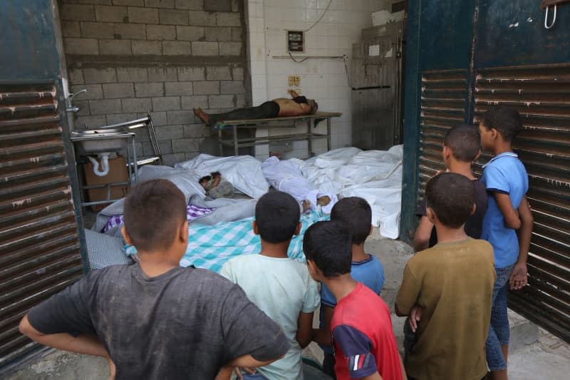 Relatives of Palestinians, who killed after an Israeli attack targeting a house in the Maghzi refugee camp, mourn after their bodies were brought to the al-Aqsa Martyrs Hospital for burial in Deir El-Balah. Omar Ashtawy/APA Images via ZUMA Press Wire/dpa