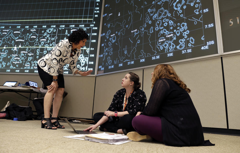 Historic Preservation Officer Sandra Tetley, left, talks with Delaney Harris-Finch, center, with Stern and Bucek Architects and Sonya Yungeberg, right, president of Ayuda Companies, as they discuss details inside the mission control room being restored to the Apollo mission era for the 50th anniversary of the Apollo moon landing at the NASA Johnson Space Center Monday, June 17, 2019, in Houston. (AP Photo/Michael Wyke)