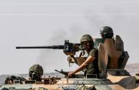 Turkish soldiers drive a tank towards Syria from the Turkish border city of Karkamis in the Gaziantep region on August 27, 2016