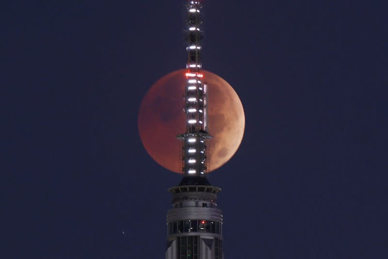 A full blood moon sets behind the Empire State Building and the Manhattan skyline during a total lunar eclipse in New York City in November 2022. File Photo by John Angelillo/UPI
