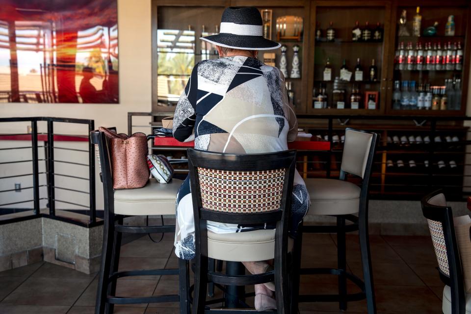 A woman enjoys happy hour at Pacifica Seafood Restaurant in Palm Desert, Calif., on April 23, 2021. 