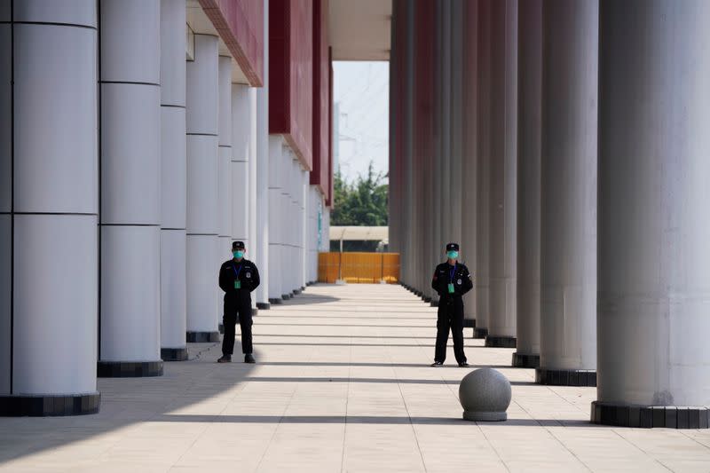 Security personnel stand guard outside a convention center that was used as a makeshift hospital in Wuhan