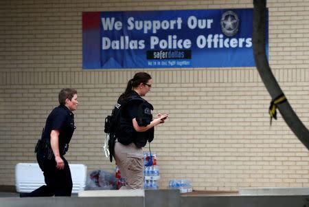 Dallas police officers enter Dallas Police Department headquarters after the all-clear signal was given due to a lockdown after an anonymous threat was reported in Dallas, Texas, U.S. July 9, 2016. REUTERS/Carlo Allegri