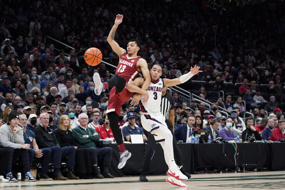 Alabama's Jahvon Quinerly, left, and Gonzaga's Andrew Nembhard (3) collide while chasing the ball during the first half of an NCAA college basketball game Saturday, Dec. 4, 2021, in Seattle. (AP Photo/Elaine Thompson)