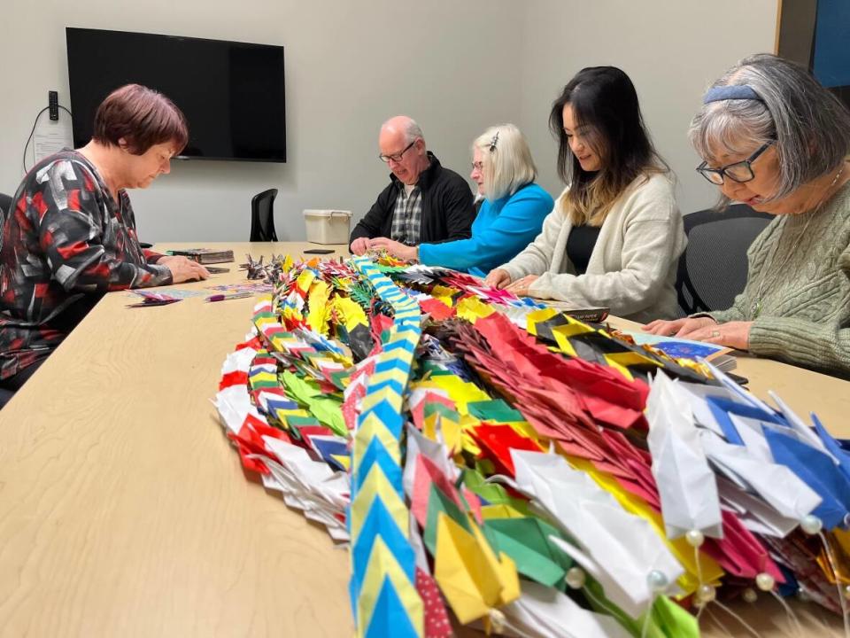 An origami teacher and her group of students at the Seniors College of P.E.I. in Charlottetown folded 1,000 paper cranes to send to the Ukrainian embassy in Ottawa as a show of hope and support for the people of Ukraine. (Brittany Spencer/CBC - image credit)