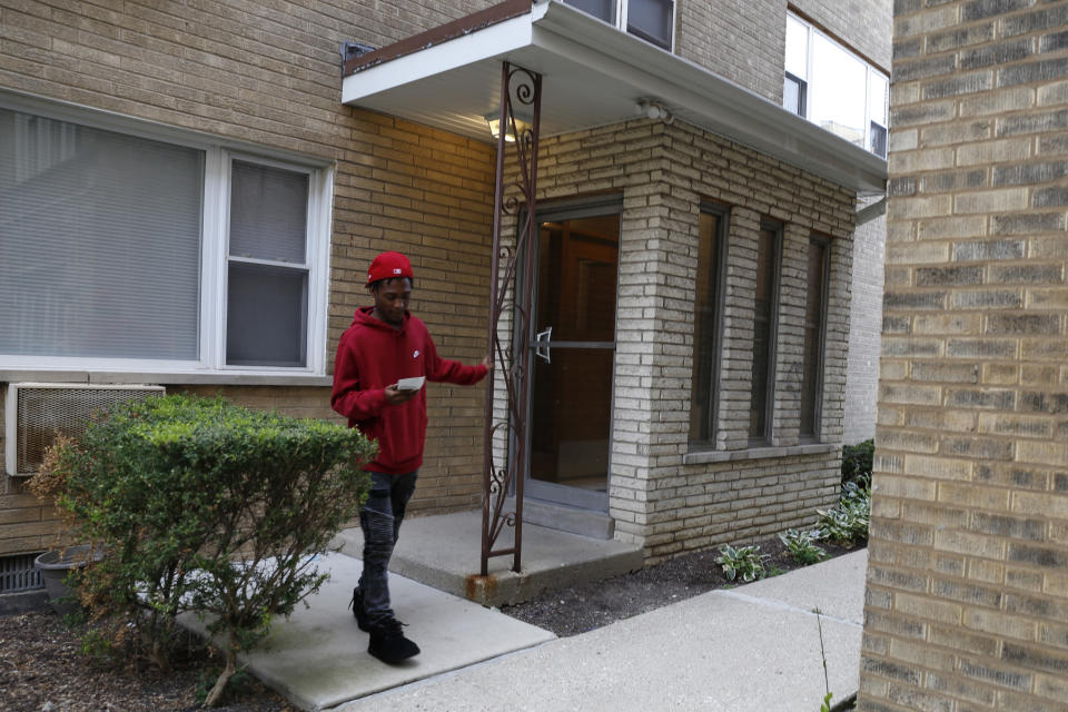 Keyon Robinson, 19, leaves his apartment to go to work at a restaurant on Monday, Aug. 15, 2022, in Oak Park, Ill. Robinson, who's facing felony charges for having a gun on his high school's campus last May, had one month before graduation when he was arrested. He recently started working at a restaurant while his case works its way through the courts. He also wants to go to community college and hopes he might get a deferred sentence as a first-time offender. (AP Photo/Martha Irvine)