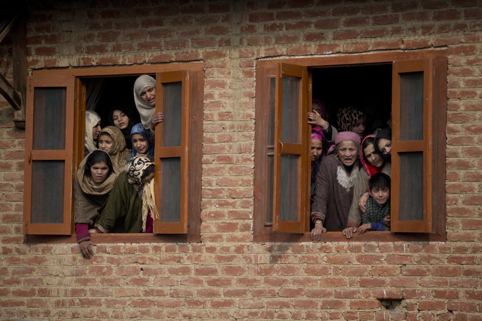 Kashmiri villagers watch the funeral procession of Umar Ramzan, a local rebel in Tral, south of Srinagar, Indian controlled Kashmir, Saturday, Dec. 22, 2018. A gunbattle between Indian troops and Kashmiri rebels early Saturday left six militants dead and triggered a new round of anti-India protests in the disputed Himalayan region. (AP Photo/Dar Yasin)
