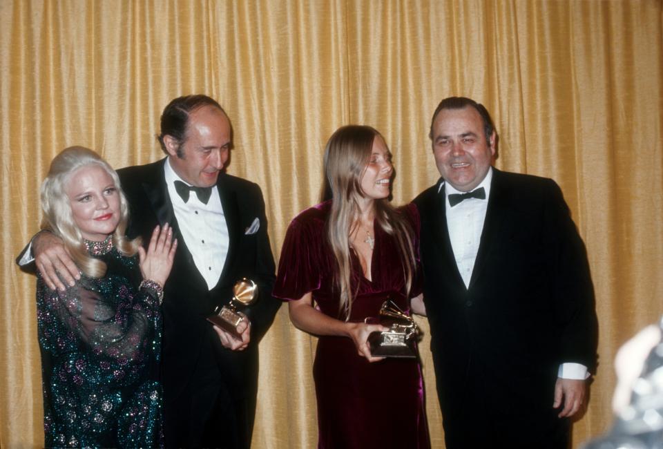 Comedian Jonathan Winters and singer Peggy Lee congratulate Grammy winners Henry Mancini and Joni Mitchell on March 11, 1970