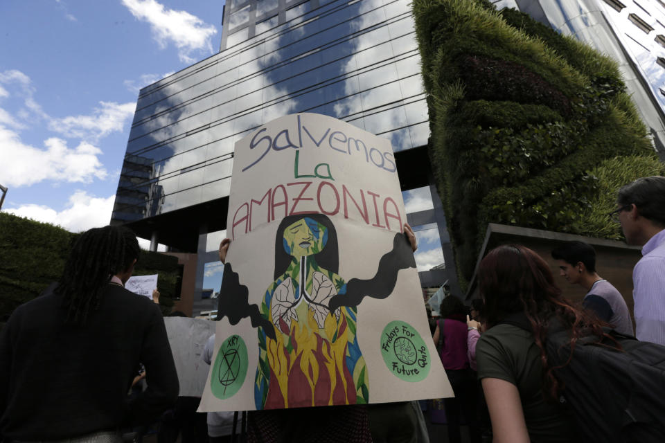 People gather outside the Brazilian embassy during a demonstration demanding something be done about the fires that have been breaking out at an unusual pace in Brazil this year, causing global alarm over deforestation in the Amazon region, in Quito, Ecuador, Friday, Aug. 23, 2019. Under increasing international pressure to contain fires sweeping parts of the Amazon, Brazilian President Jair Bolsonaro on Friday authorized use of the military to battle the massive blazes. (AP Photo/Dolores Ochoa)