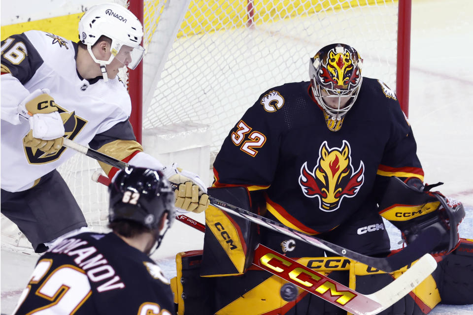 Vegas Golden Knights' Pavel Dorofeyev, left, has a shot stopped by Calgary Flames goalie Dustin Wolf during the second period of an NHL hockey game Thursday, March 14, 2024, in Calgary, Alberta. (Larry MacDougal/The Canadian Press via AP)