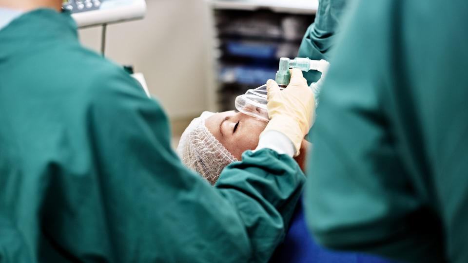 Shot of an anesthesiologist and surgeons working on a patient in an operating room.