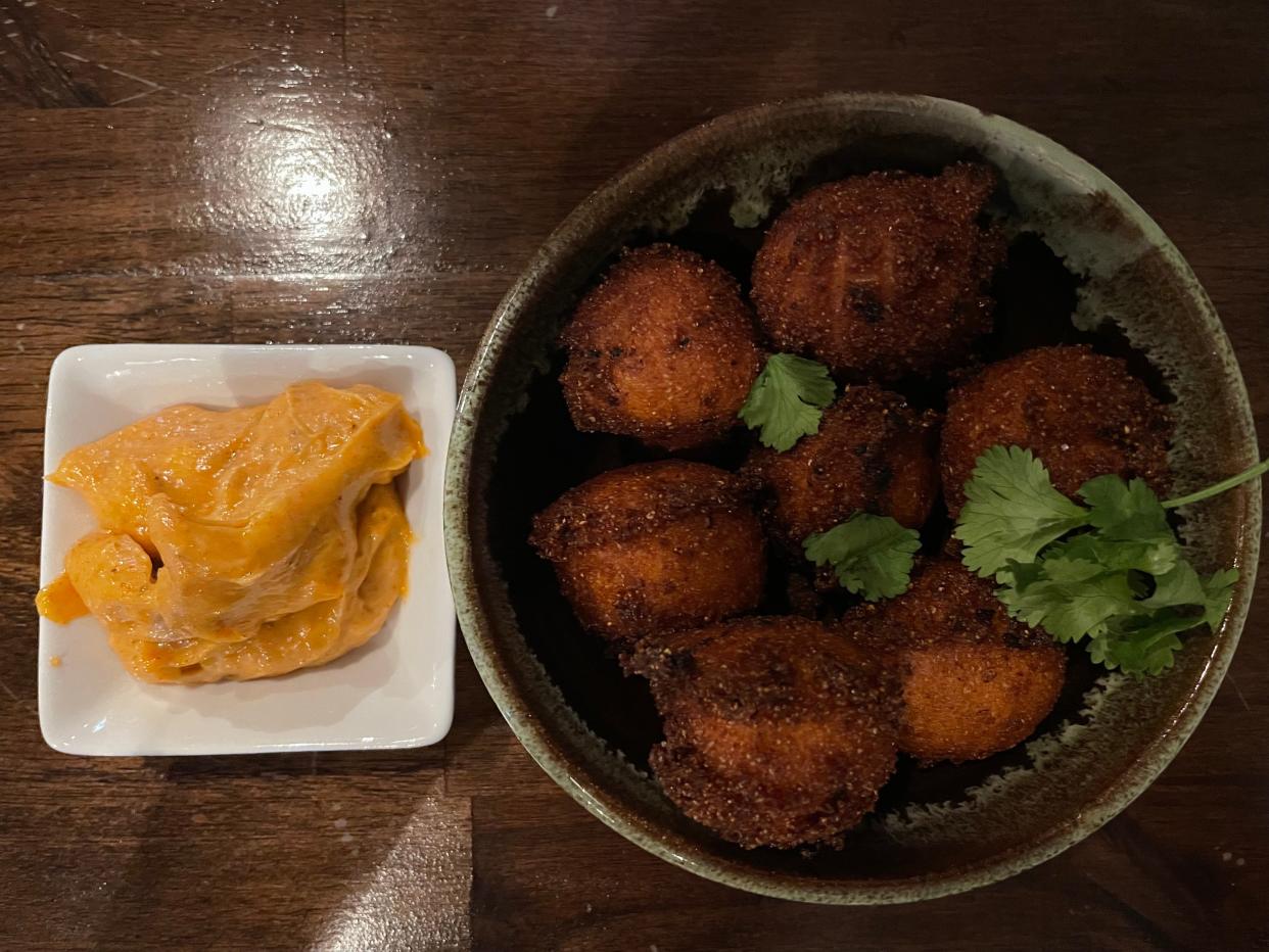 The smoked-lobster hush puppies at The Humble Hog on Gay Street in downtown Knoxville come with a dipping sauce.