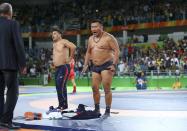 <p>The coach of Mandakhnaran Ganzorig (MGL) of Mongolia takes off his clothes as he protests after the match against Ikhtiyor Navruzov (UZB) of Uzbekistan. (Reuters) </p>