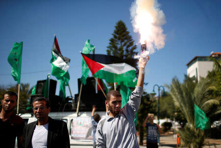 A man releases fireworks during celebrations after rival Palestinian factions Hamas and Fatah signed a reconciliation deal, in Gaza City October 12, 2017. REUTERS/Suhaib Salem