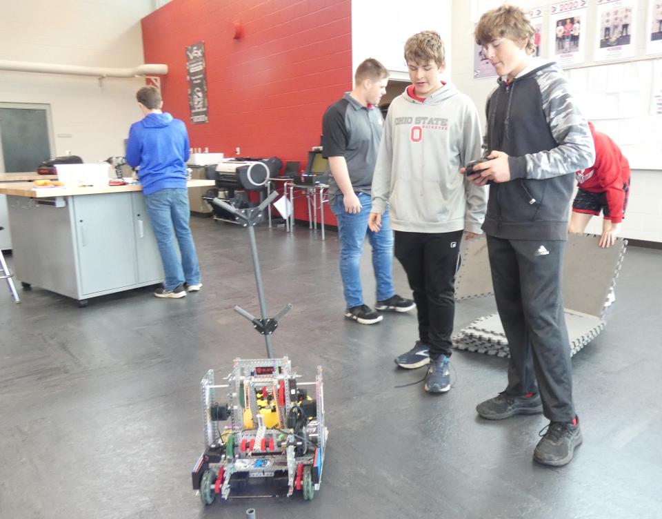 Twin brothers J.J. Hiler and Isaac Hiler, from left, work with their team's robot in the Buckeye Central High School STEAM lab on Monday morning.