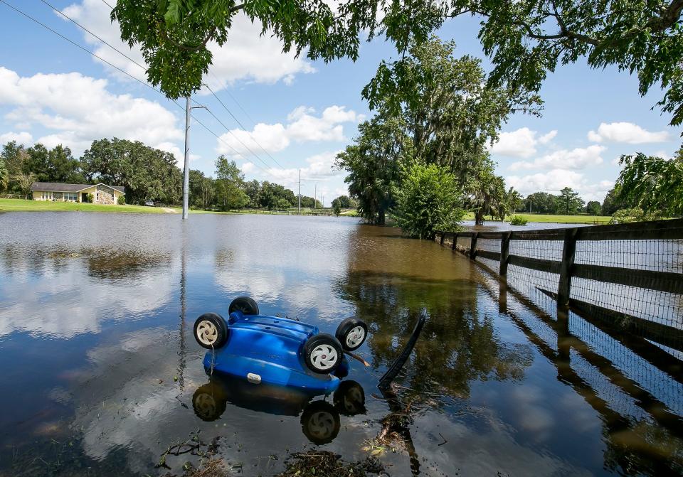 A children's wagon rests upside down in the flooded front yard of the Hislop property at 6325 S. Magnolia Ave. in Ocala after Hurricane Irma moved through.