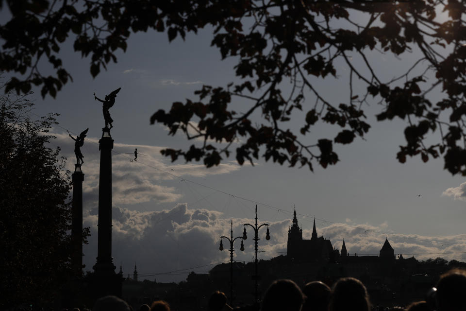 French tightrope walker Tatiana-Mosio Bongoga balances over the Vltava river during her performance to open an international new circus festival in Prague, Czech Republic, Wednesday, Aug. 14, 2019. The Prague Castle is in the background. (AP Photo/Petr David Josek)