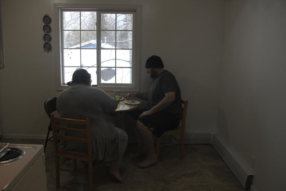 Airis Messick, left, and Brian Messick, right, eat lunch at their apartment in Anchorage, Alaska, on Wednesday, Nov. 11, 2020. Messick and her husband have had to turn to food banks after both lost their jobs in the economic downturn caused by the coronavirus pandemic. (AP Photo/Mark Thiessen)