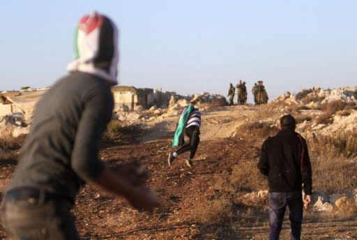 Masked Palestinian youths throw stones as they clash with Israeli security forces in the West Bank village of al-Khader, near Bethlehem, on November 15, 2012. Israel gave the go-ahead to call up 30,000 reservists and warned it was ready to expand its offensive in the Gaza Strip after militants targeted Tel Aviv with rockets for the first time since the 1991 Gulf War