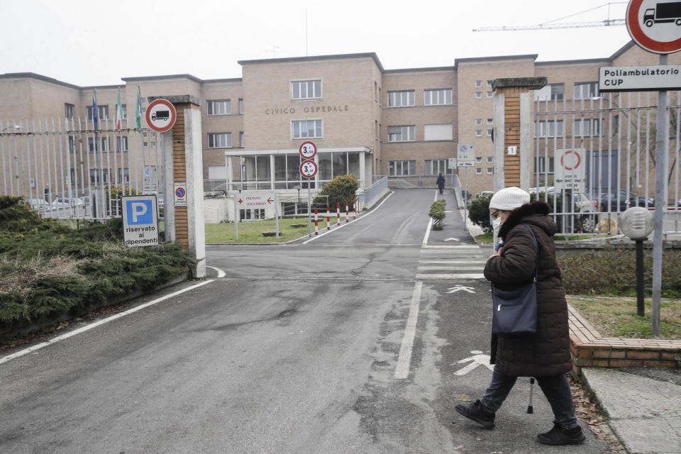 A woman walks in front of the Civic Hospital in Codogno, northern Italy, Sunday, Feb. 21, 2021. The first case of locally spread COVID-19 in Europe was found in the small town of Codogno, Italy one year ago on February 21st, 2020. The next day the area became a red zone, locked down and cutoff from the rest of Italy with soldiers standing at roadblocks keeping anyone from entering of leaving. (AP Photo/Luca Bruno)