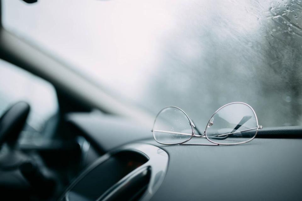 Eyeglasses with aviator frames on car dashboard, upside-down.