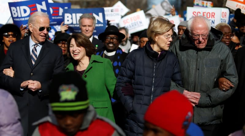 Seven of the Democratic US Presidential candidates walk arm-in-arm with local African-American leaders during the Martin Luther King Jr. (MLK) Day Parade in Columbia