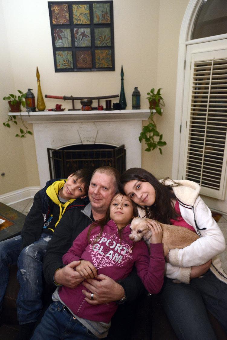 In this photo from Feb. 23, 2014, David Bundy arrives home to Montgomery, Ala., with three of their newly adopted four children, Max from left, Alla and Karina. Bundy's wife, Lisa remained in Ukraine until the adoption of their daughter Nastia could be finalized. (AP Photo/Montgomery Advertiser, Amanda Sowards) NO SALES.