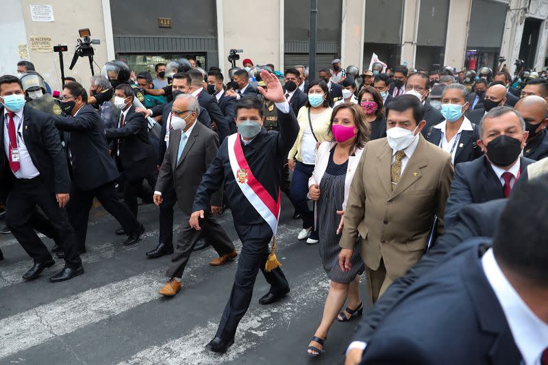 Peru's President Pedro Castillo waves as he walks a day after lawmakers voted to start an impeachment process against him, in Lima