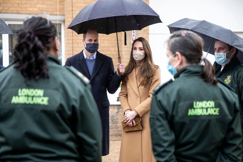 Britain&#39;s Prince William, Duke of Cambridge (L) and Britain&#39;s Catherine, Duchess of Cambridge (2R), both wearing face coverings due to Covid-19, talk with members of the ambulance service in the wellbeing garden during a visit to Newham Ambulance Station in east London on March 18, 2021, where they learned about their experiences during the coronavirus pandemic. (Photo by RICHARD POHLE / POOL / AFP) (Photo by RICHARD POHLE/POOL/AFP via Getty Images)