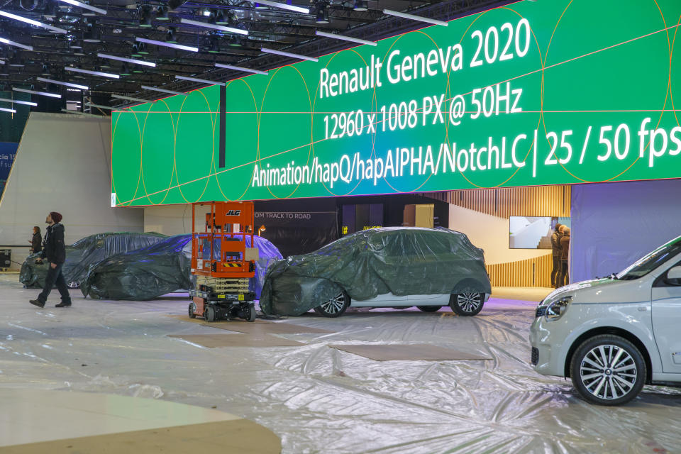 Cars are pictured as workers stop the preparation of the 90th Geneva International Motor Show, GIMS, at Palexpo, in Geneva, Switzerland, Friday, Feb. 28, 2020. The 90th edition of the International Motor Show, scheduled to begin on March 5th, is cancelled due to the advancement of the (Covid-19) coronavirus in Switzerland. The Swiss confederation announced today that all events involving more than 1,000 people would be banned until 15 March. (Salvatore di Nolfi/Keystone via AP)