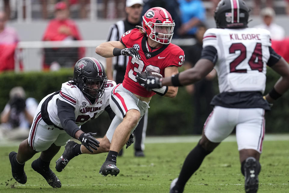 Georgia running back Cash Jones (32) is brought down by South Carolina defensive tackle Tonka Hemingway (91) after making a catch during the first half of an NCAA college football game Saturday, Sept. 16, 2023, Ga. (AP Photo/John Bazemore)
