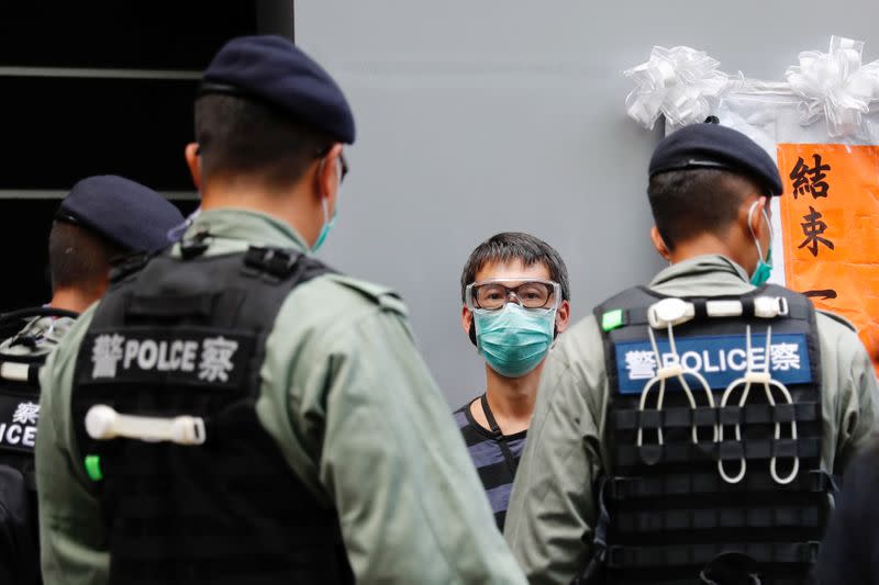 Police search a pro-democracy protester during a demonstration on the anniversary of Hong Kong's handover to China