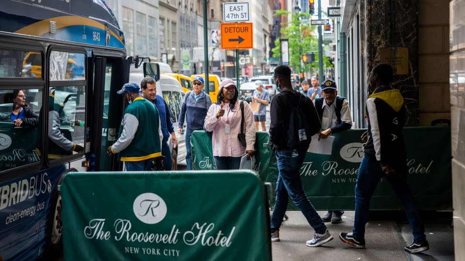 Migrants are seen boarding a bus at the Roosevelt Hotel on May 21, 2023, soon after the hotel became an intake center. - Evelio Contreras/CNN