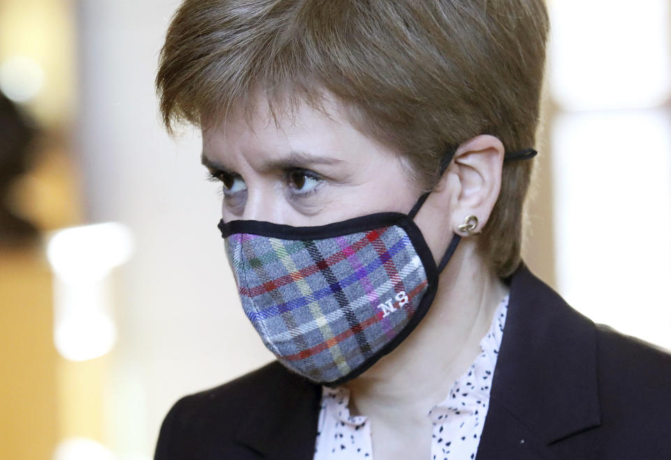 Scotland's First Minister Nicola Sturgeon wears a mask to protect from coronavirus, in the Scottish Parliament at Holyrood prior to a making a statement outlining further coronavirus restrictions for Scotland, in Edinburgh, Wednesday, Oct. 7, 2020. The Scottish government is banning indoor drinking at bars and forcing restaurants to close in the evening to help contain the coronavirus. First Minister Nicola Sturgeon says the measures were “a short, sharp action” and will last for 16 days starting Friday.  (Andrew Milligan/PA via AP)