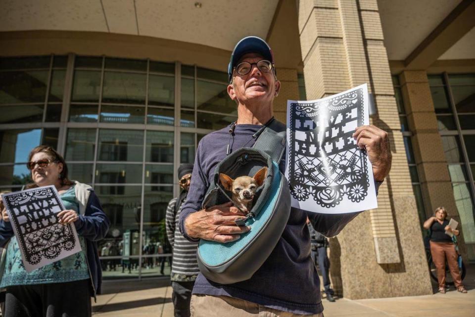 Alan LoFaso of Sacramento holds his dog Pilar and a “Love Not Hate” sign as members of The Jewish Federation of the Sacramento Region and community leaders hold a press conference on Tuesday, May 30, 2023, in response to antisemitic and racist public comments made a recent Sacramento City Council meetings.