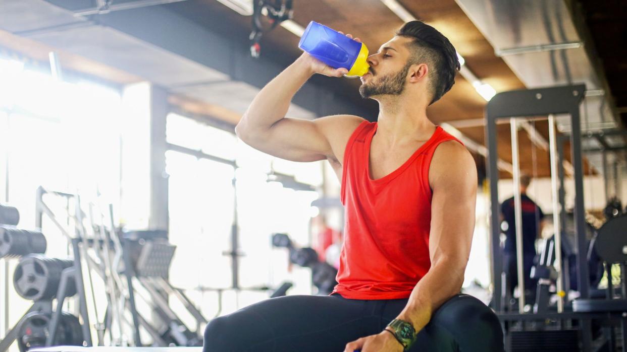  Man drinking pre-workout in the gym. 