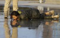 A female trainee lies on the ground after being drenched with water during Tianjiao Special Guard/Security Consultant training on the outskirts of Beijing December 1, 2013. Former Chinese soldier Chen Yongqing has big ambitions for his bodyguard training school Tianjiao, which he says is China's first professional academy to train former soldiers and others as personal security guards. Chen charges 500,000 yuan ($82,400) a year for each protector as China's rich and famous look to bolster their safety and sense of importance. Picture taken December 1, 2013. REUTERS/Jason Lee (CHINA - Tags: BUSINESS SOCIETY) ATTENTION EDITORS: PICTURE 10 OF 26 FOR PACKAGE 'CHINA'S BODYGUARD SCHOOL' TO FIND ALL IMAGES SEARCH 'TIANJIAO'