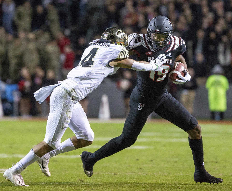 North Carolina State's C.J. Riley (19) carries the ball as Wake Forest's Amari Henderson (4) attempts a tackle during the first half of an NCAA college football game in Raleigh, N.C., Thursday, Nov. 8, 2018. (AP Photo/Ben McKeown)