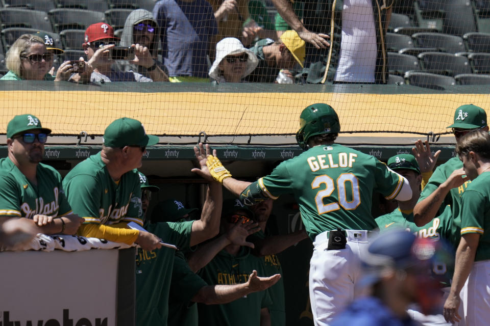 Oakland Athletics' Zack Gelof (20) celebrates with teammates at the dugout after hitting a solo home run against the Texas Rangers during the sixth inning of a baseball game Wednesday, Aug. 9, 2023, in Oakland, Calif. (AP Photo/Godofredo A. Vásquez)