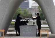 The name list of war dead is given to Hiroshima City mayor Kazumi Matsui from a representative of bereaved families of the 1945 atomic bombing victims at Peace Memorial Park in Hiroshima