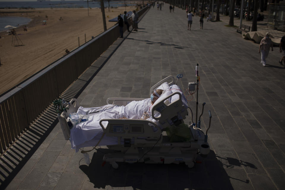 Francisco España, 60, spends time in front of the beach near the "Hospital del Mar" in Barcelona, Spain, Friday, Sept. 4, 2020. A hospital in Barcelona is studying how short trips to the beach may help COVID-19 patients recover from long and traumatic intensive hospital care. The study is part of a program to “humanize” ICUs. Since re-starting it in early June, the researchers have anecdotally noticed that even ten minutes in front of the blue sea waters can improve a patient’s emotional attitude. (AP Photo/Emilio Morenatti)