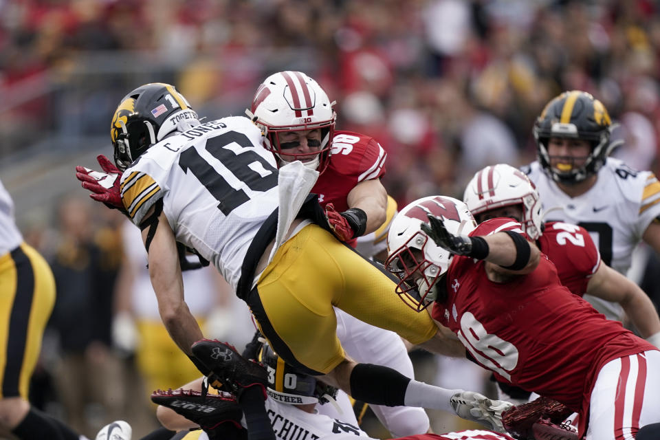 Wisconsin's linebacker C.J. Goetz (98) and safety Collin Wilder (18) stop Iowa wide receiver Charlie Jones (16) during the first half of an NCAA college football game Saturday, Oct. 30, 2021, in Madison, Wis. (AP Photo/Andy Manis)